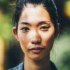 Portrait of a young woman with black hair tied in a top knot, looking at camera.,Ho Chi Minh City Portrait of a young woman with black hair tied in a top knot, looking at camera.