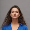 Young gorgeous woman with perfect makeup and dark long wavy hair Young gorgeous woman with perfect makeup and dark long wavy hair standing in front of camera over grey background