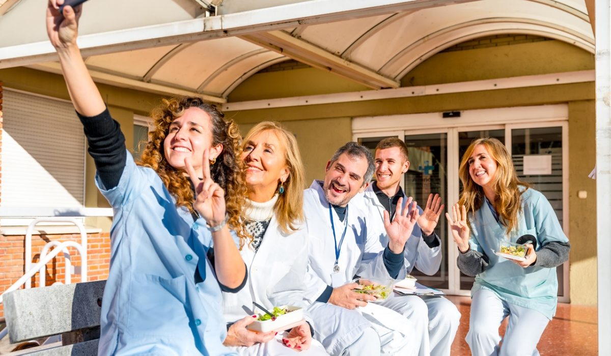 Medical staff taking a selfie outdoors during a lunch break Smiling medical staff taking a selfie with mobile outdoors during a lunch break