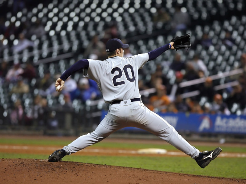 A baseball pitcher demonstrating the extreme force and stressed position of the arm during windup