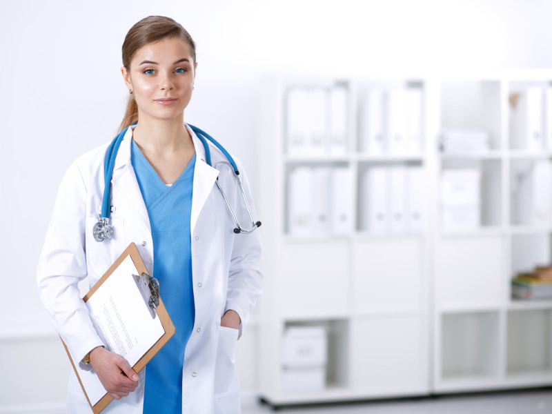 Female TOS surgeon with blue eyes holds a clipboard